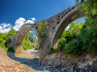 Fototapeta na wymiar Old Kalogeriko triple arched stone bridge on Vikos canyon, Zagorohoria, Greece