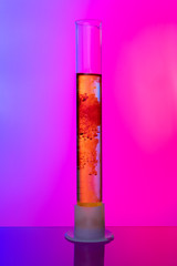 Laboratory glass tubes with chemicals on bright pink background