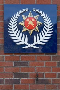 Close Up Of The New Zealand Fire Service Sign/Logo On A Brick Wall