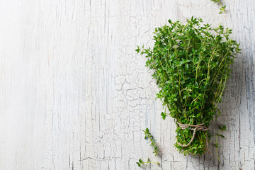 Bunch of fresh thyme on cracked white wooden background. Top view. Copy space. - obrazy, fototapety, plakaty