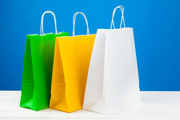 Paper shopping bags with copy space on blue background