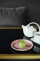Portion of modern cake and tea on table, food close-up