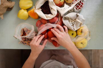 Women's hands with dry beans, cotton bags
