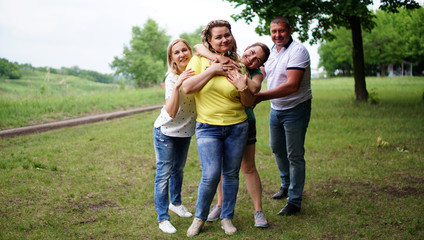 Fototapeta premium Cute middle aged group embracing one another outdoors in a park