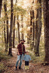 Obraz premium Happy father and son in autumn park.