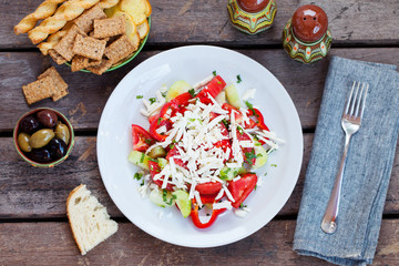 Vegetable Bulgarian Shopska salad. Wooden background. Top view.