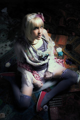 beautiful young blond woman in  colorful boho style  clothes sit in dark room on floor shot from above