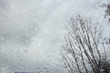 Drops on the glass outside the window dry wood