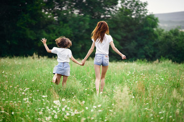 mother and daughter running in the field