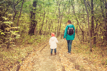 Obraz premium Mother and daughter are walking in the autumn forest