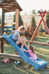Sisters having fun on a slide together