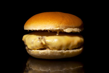 Fast food concept: hamburger with large beef patty and melted cheese  on a black background