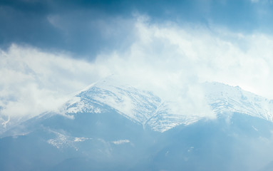 Fototapeta na wymiar Foggy hills and gloomy mood of the scene of the alpine valley.