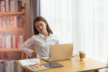 Businesswoman feeling pain in spine back after sedentary computer work sitting in bad posture in...