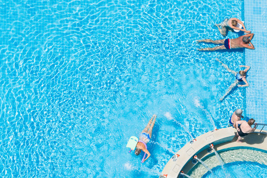 People Relax By The Pool, Swim And Sunbathe, View From Above.