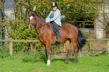 Older woman riding horse in field