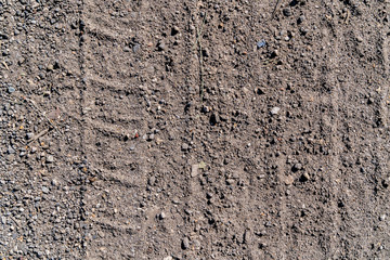 Slightly prominent tire tracks of the car on a gray ground