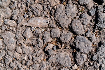 Texture of stone ground. Asphalt is broken into little rocks. Old surface