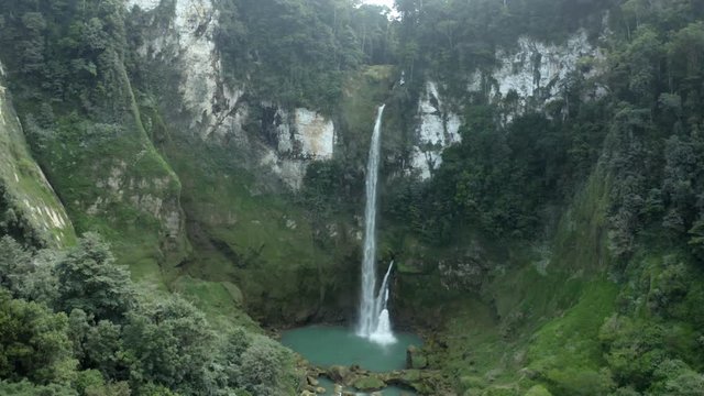 Forward drone shot of Matayangu Waterfall, Sumba, surrounded by cliffs and trees