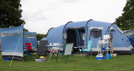 All pitched and ready to camp, a tent and camping equipment set up ready for holidays/ Vacation.