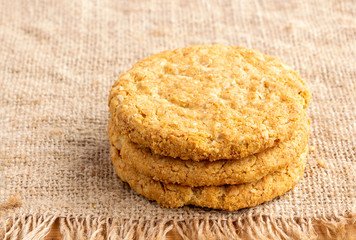 Homemade oat and wholemeal biscuits isolated on brown sackcloth background. Its are a nutrient-rich food associated with protein, fiber and no artificial flavours or colour added.