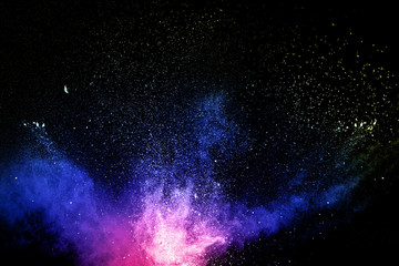 Multi colored powder explosion  on black background.Colorful dust splash cloud  on dark background.