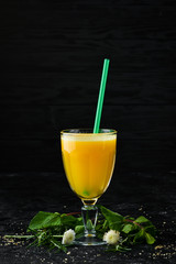 Fresh orange juice in a glass. Top view. On a black background.
