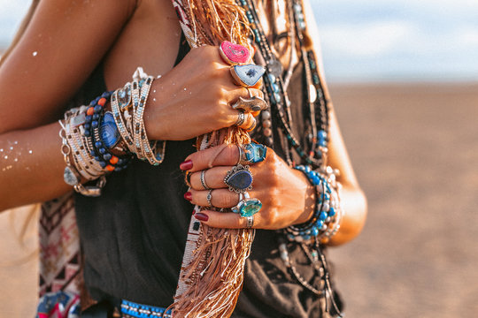 close up of young boho style woman hands with lots of accessories