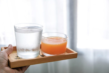 The water and orange juice are placed in a wooden tray, suitable for drinking to refresh and heal the body.