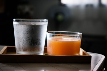 The water and orange juice are placed in a wooden tray, suitable for drinking to refresh and heal the body.