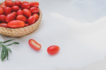 Fresh tomatoes and rosemary on a white background.