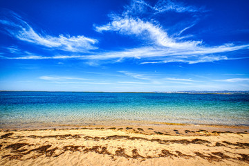Beach with yellow sand, blue water and sky