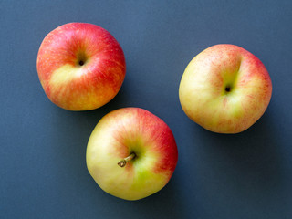 Yellow-red apples on a dark background.