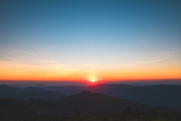 Fototapeta na wymiar Dramatic sunset and sunrise with sun flare over mountain valley morning twilight evening sky.