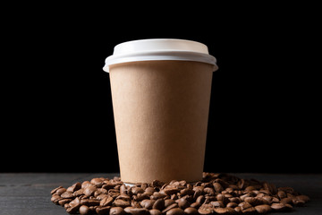  Paper cup of coffee and coffee beans on dark wooden table. Good quality coffee