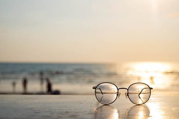 Fototapeta na wymiar Fashion sunglasses on Summer sea beach with clear blue sky. Holiday vacation relax background.