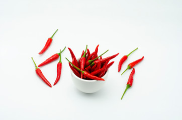 Red rot chilli in a white bowl on white background.