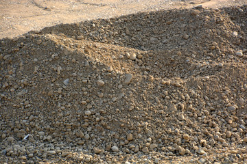 gravel pit excavation site in the evening sun, pile of gravel and stones at a construction site in an excavation pit