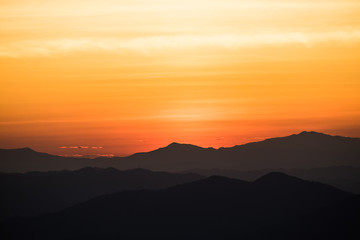 Dramatic sunset and sunrise over mountain morning twilight over evening sky horizon.