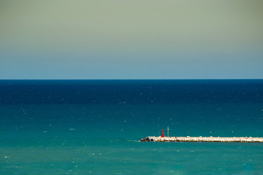 red lighthouse tower on the pier of San Benedetto del Tronto port