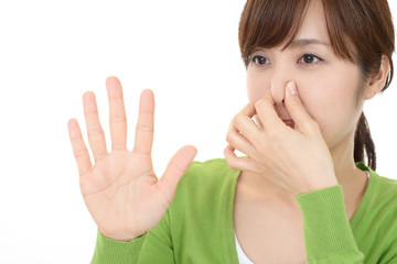 鼻をつまむ女性
