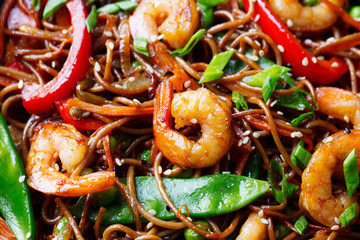 Stir fry noodles with vegetables and shrimps close up.