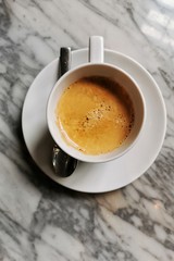 cup of coffee with cream on marble background