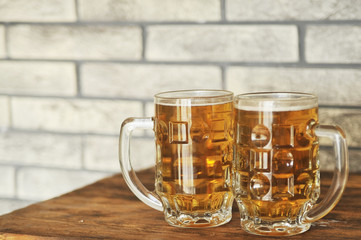 Two glasses of light beer on wooden table. Oktoberfest concept.