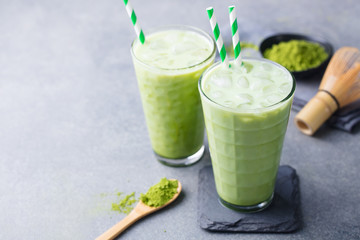 Matcha green tea ice latte with matcha powder and bamboo whisk. Copy space.
