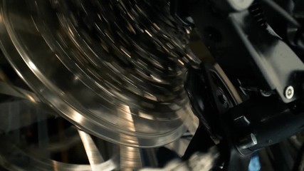 Close-up on rear bike cassette rotating with chain and changing gear