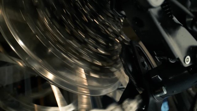 Close-up on rear bike cassette rotating with chain and changing gear