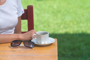  girl drinks coffee outdoors in a cafe
