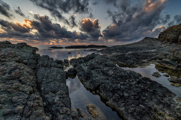 Sunrise over the rocky seaside.