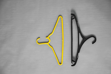 a yellow hanger lies among ordinary hangers